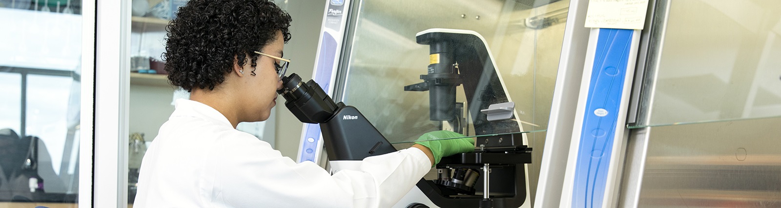 Researcherpeeringintomicroscope