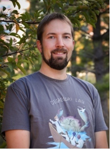 Headshot of a bearded man in a graphic tshirt