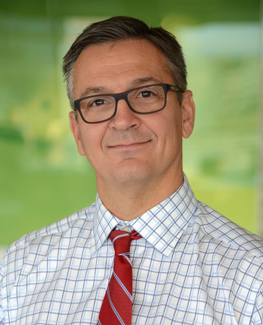 middle age man with glasses in a windowpane plaid shirt with a red tie