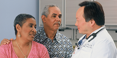 two patients speak to a doctor in a white coat