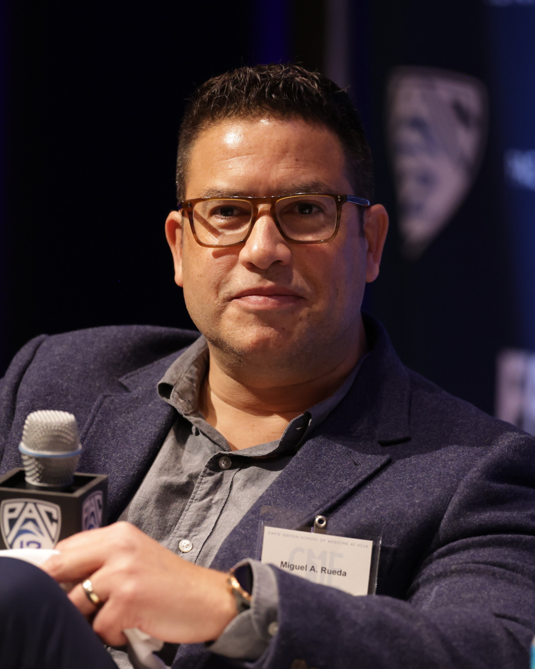 Man in glasses with a dark blue blazer