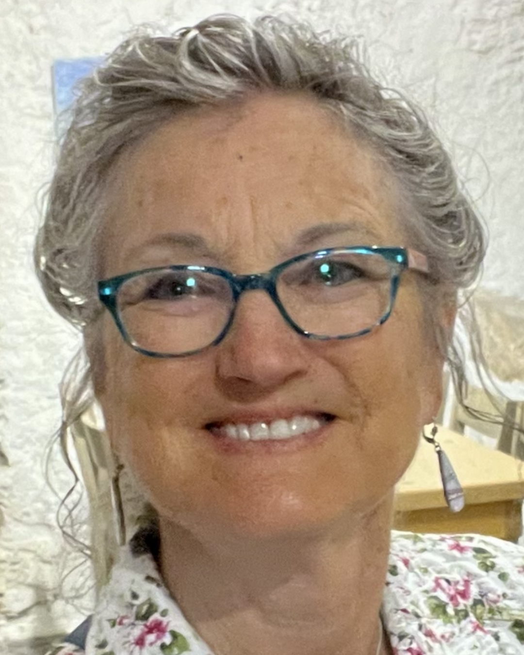 Woman in glasses with white wavy hair