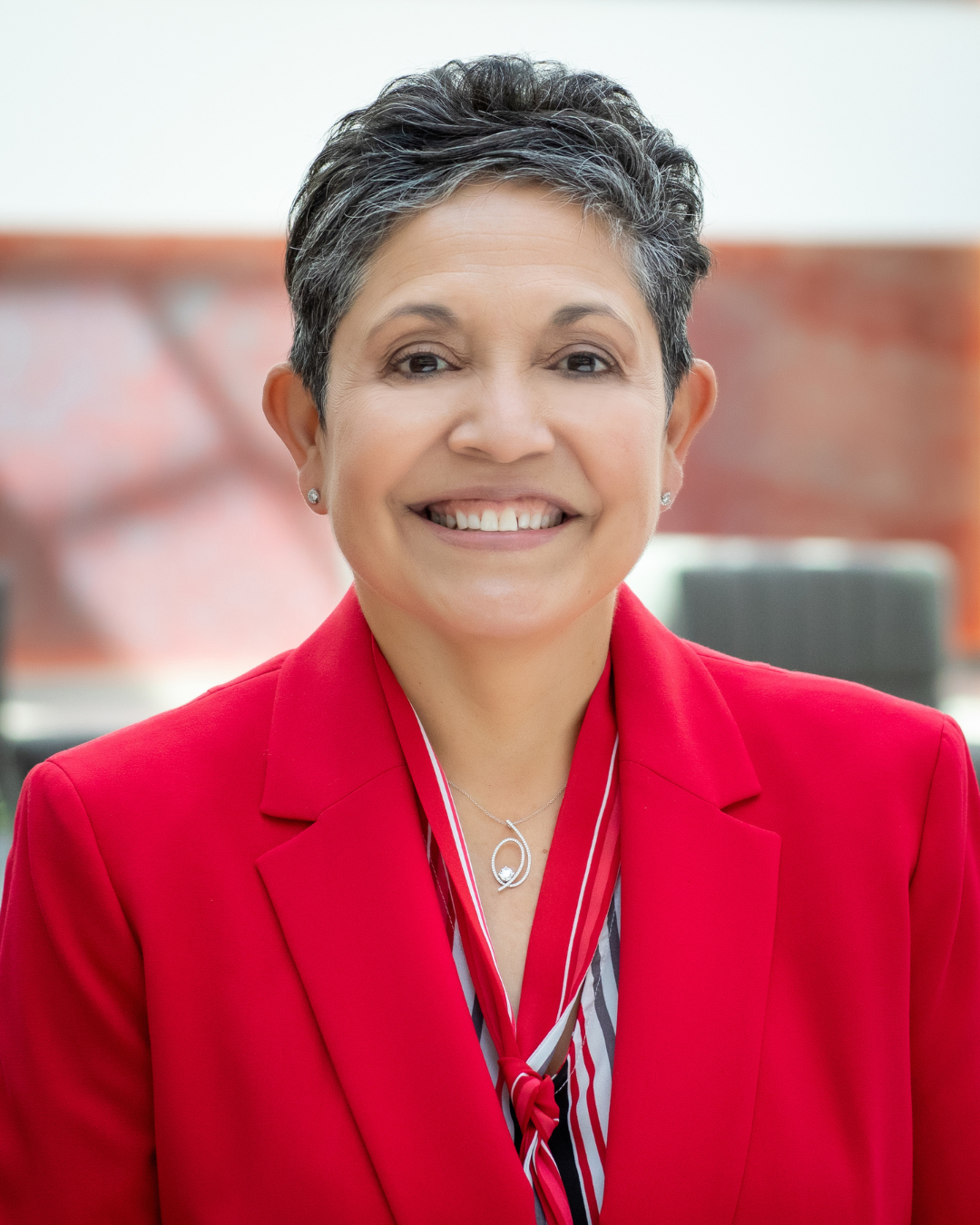 Woman in a red blazer with a pixie cut