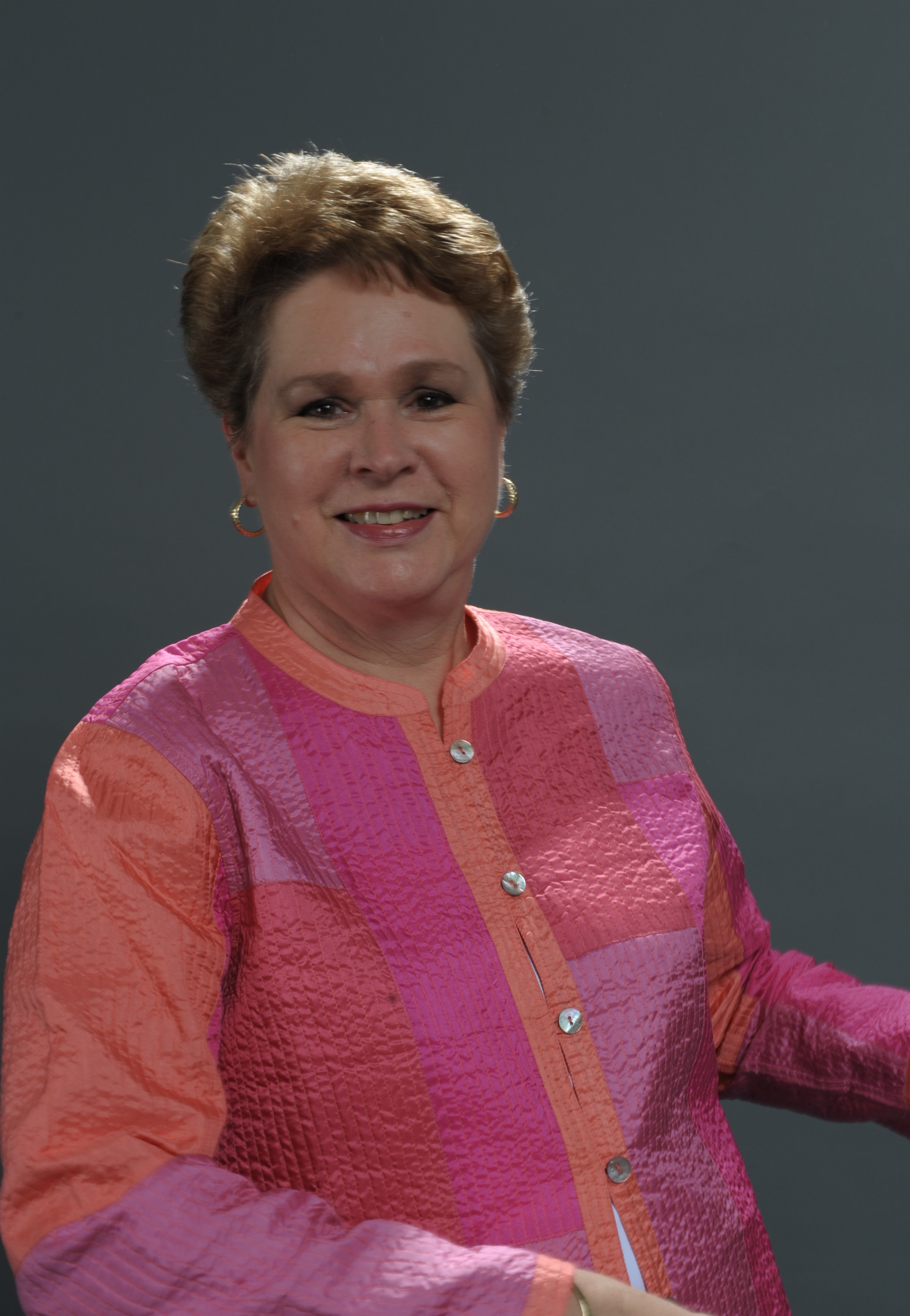 Woman with short hair in fuschia and orange jacket
