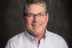 man in light grey button up shirt and glasses