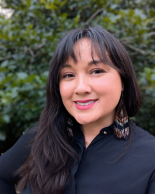 Brunette woman with bangs in a blue button up