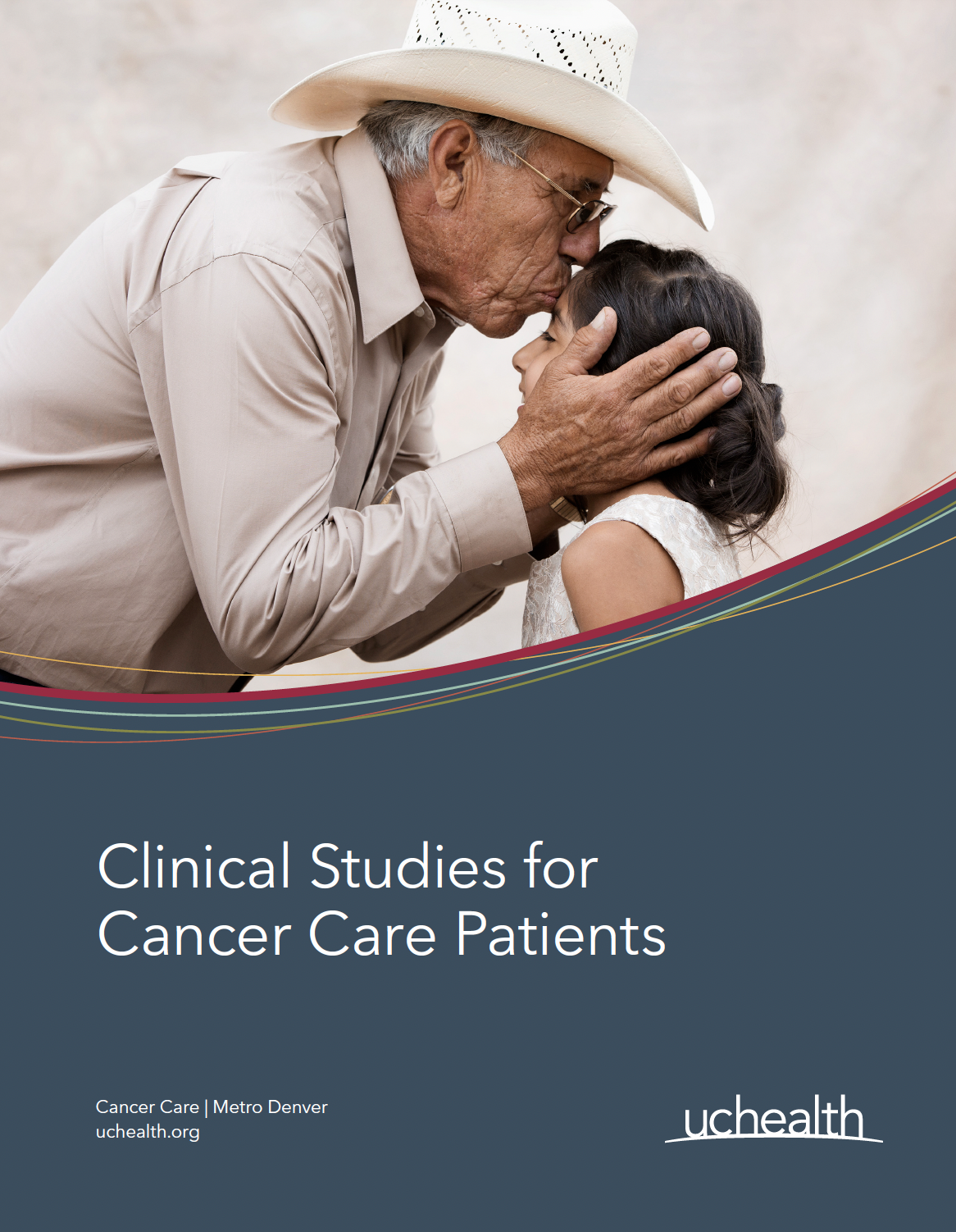 Man in cowboy hat kissing granddaughter's forehead