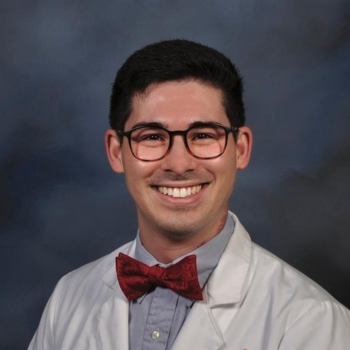 man in white coat, glasses, and red bow tie