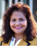 Woman in mustard blazer with a blowout