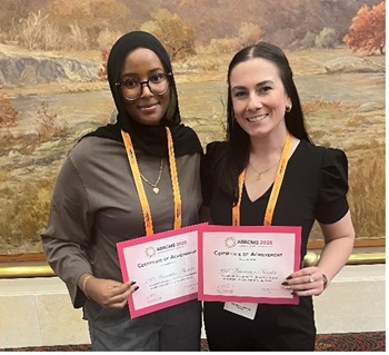 Two women holding certificates