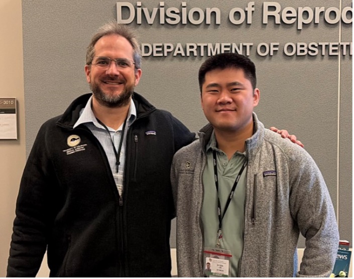 two men standing side by side in zip ups