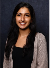 Indian woman in a black shirt and grey sweater