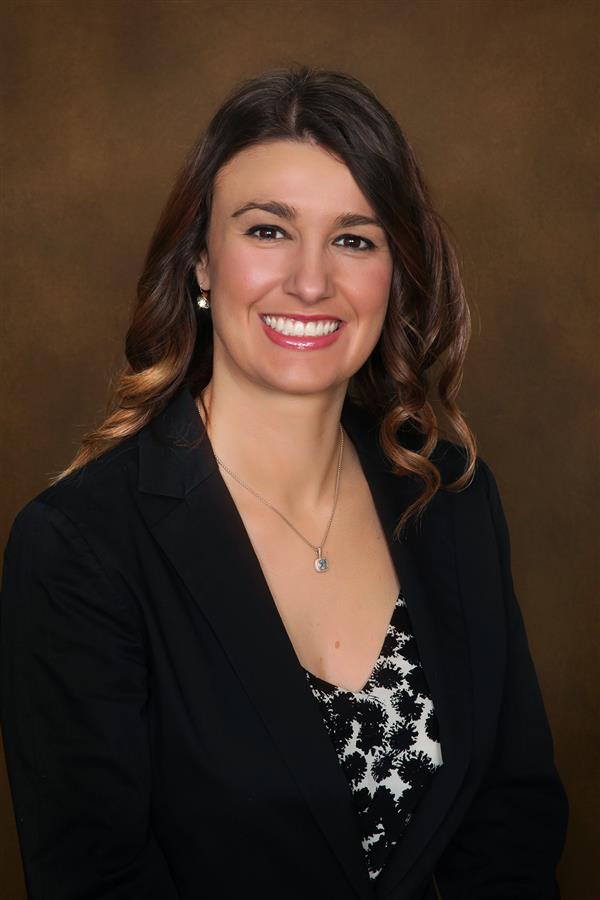 Brunette woman in black and white shirt with a black blazer on top