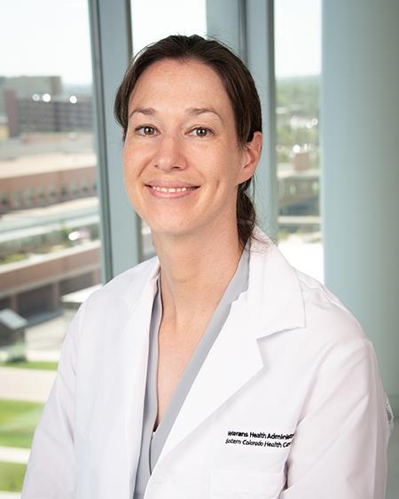 Woman in a white coat and grey blouse