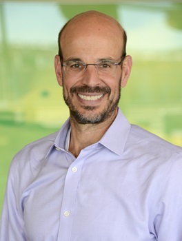 bald man with a close cropped beard in a blue button up