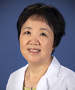 An Asian woman with a short haircut in a white labcoat