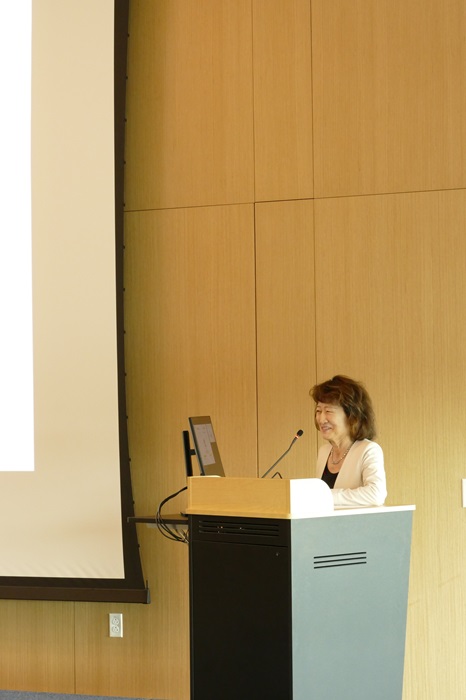 Mayumi Fujita at a podium, presenting