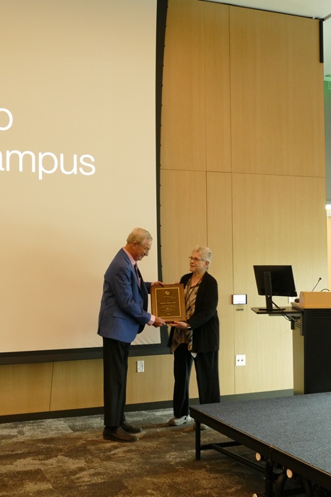 Dr. Cheryl Armstrong presenting David Norris a plaque of appreciation for 50 years of service