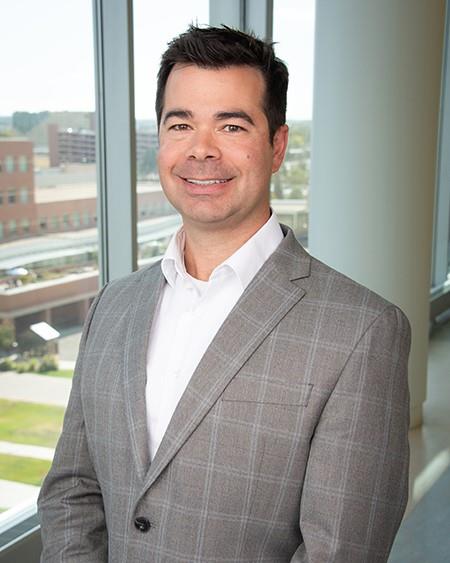 Professional headshot of Adam Terella, MD, smiling by a window