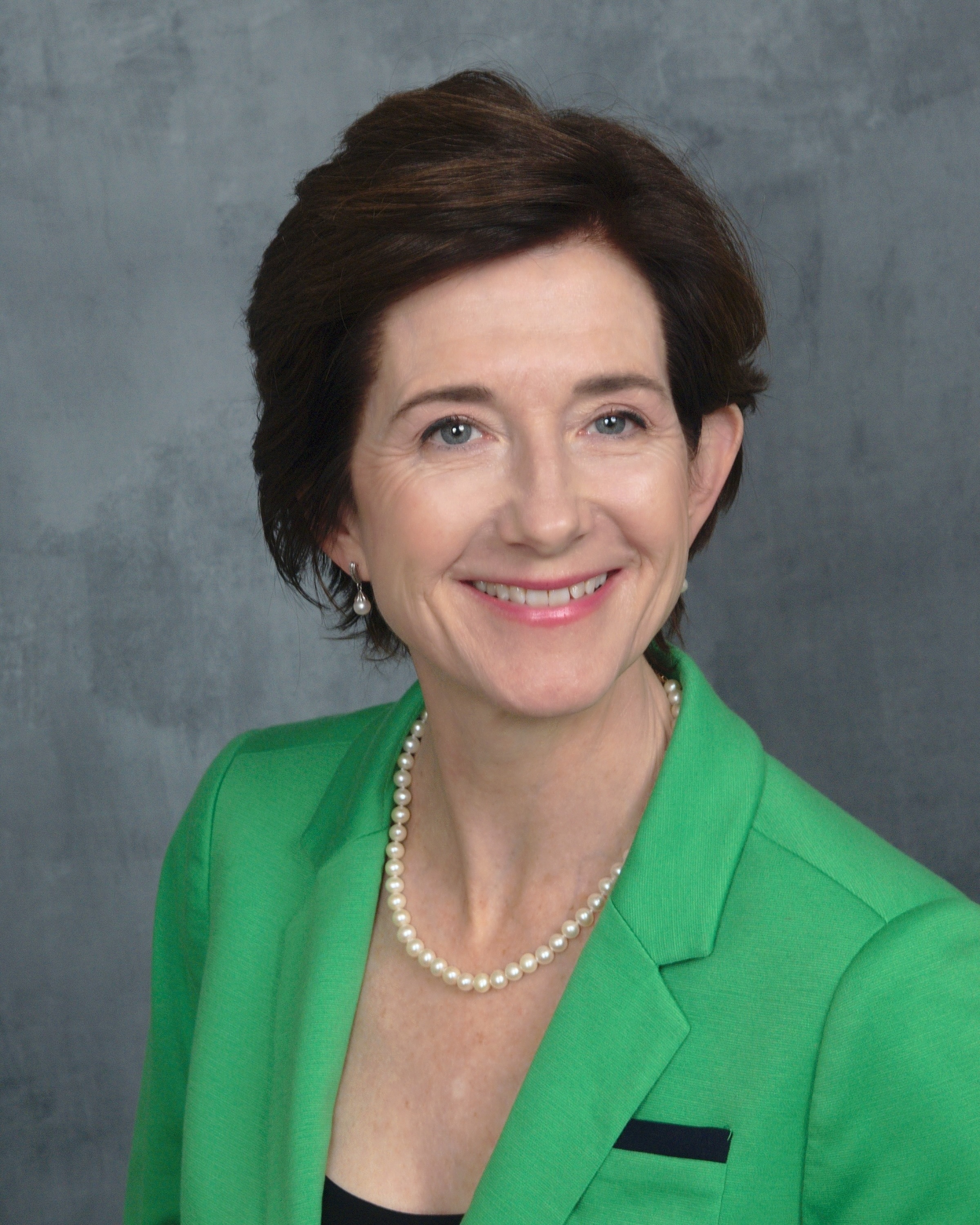 Professional picture of Fiona Zwald, MD, smiling and wearing a bright green blazer