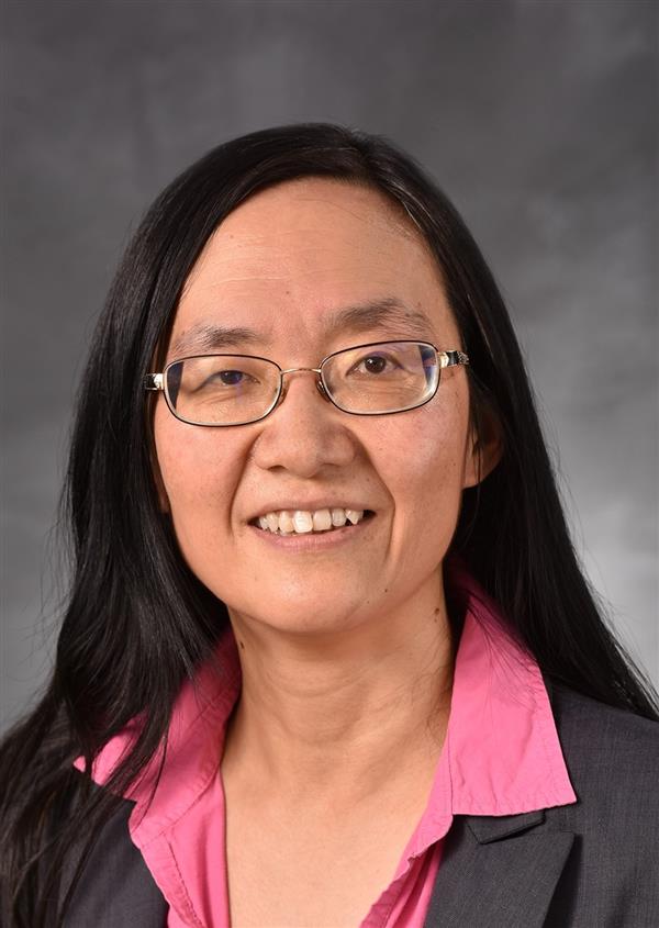Yiqun Shellman, PhD, professional picture wearing a pink shirt, grey blazer, and glasses