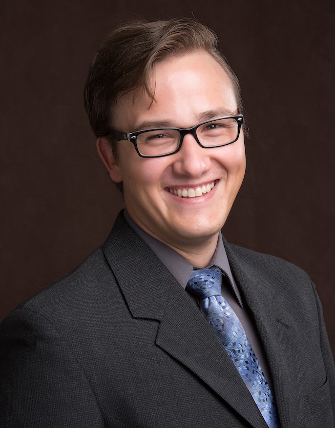 Professional photo of Jesse Hinshaw, MD, smiling and wearing a black suit and blue tie.