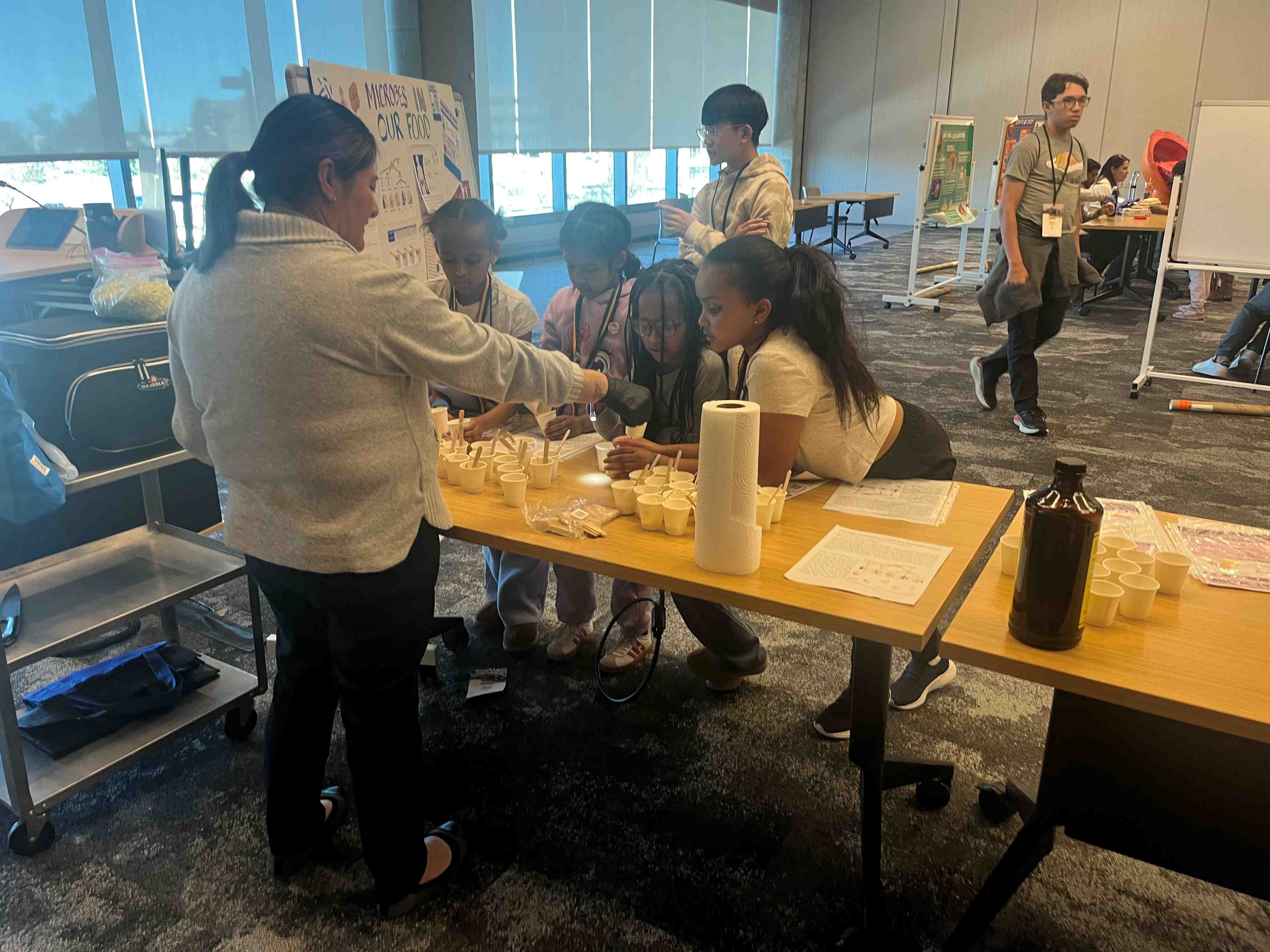 Photooftablewithyouthscienceactivitywithvolunteersandstudents