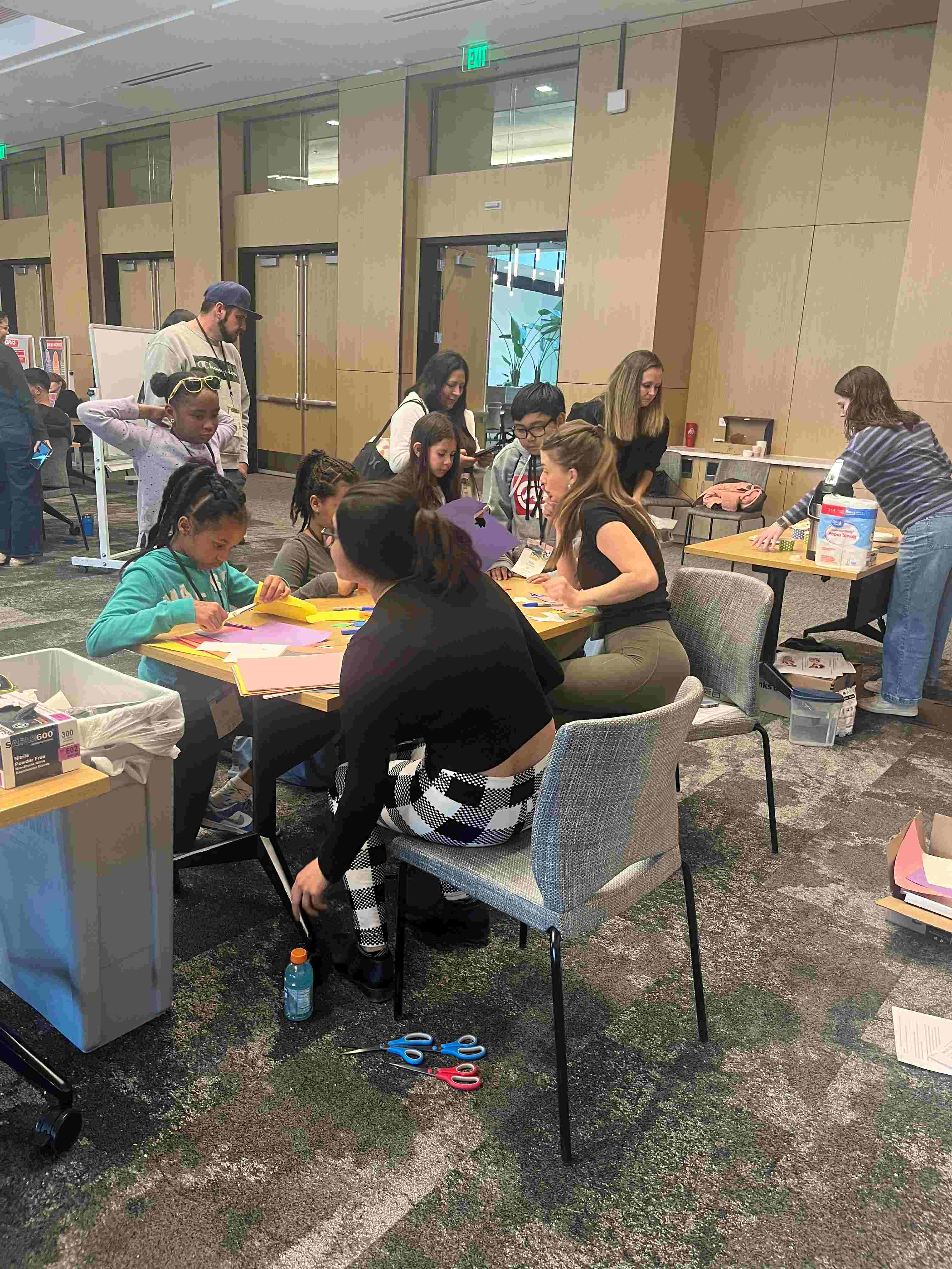 Photooftablewithyouthscienceactivitywithvolunteersandstudents