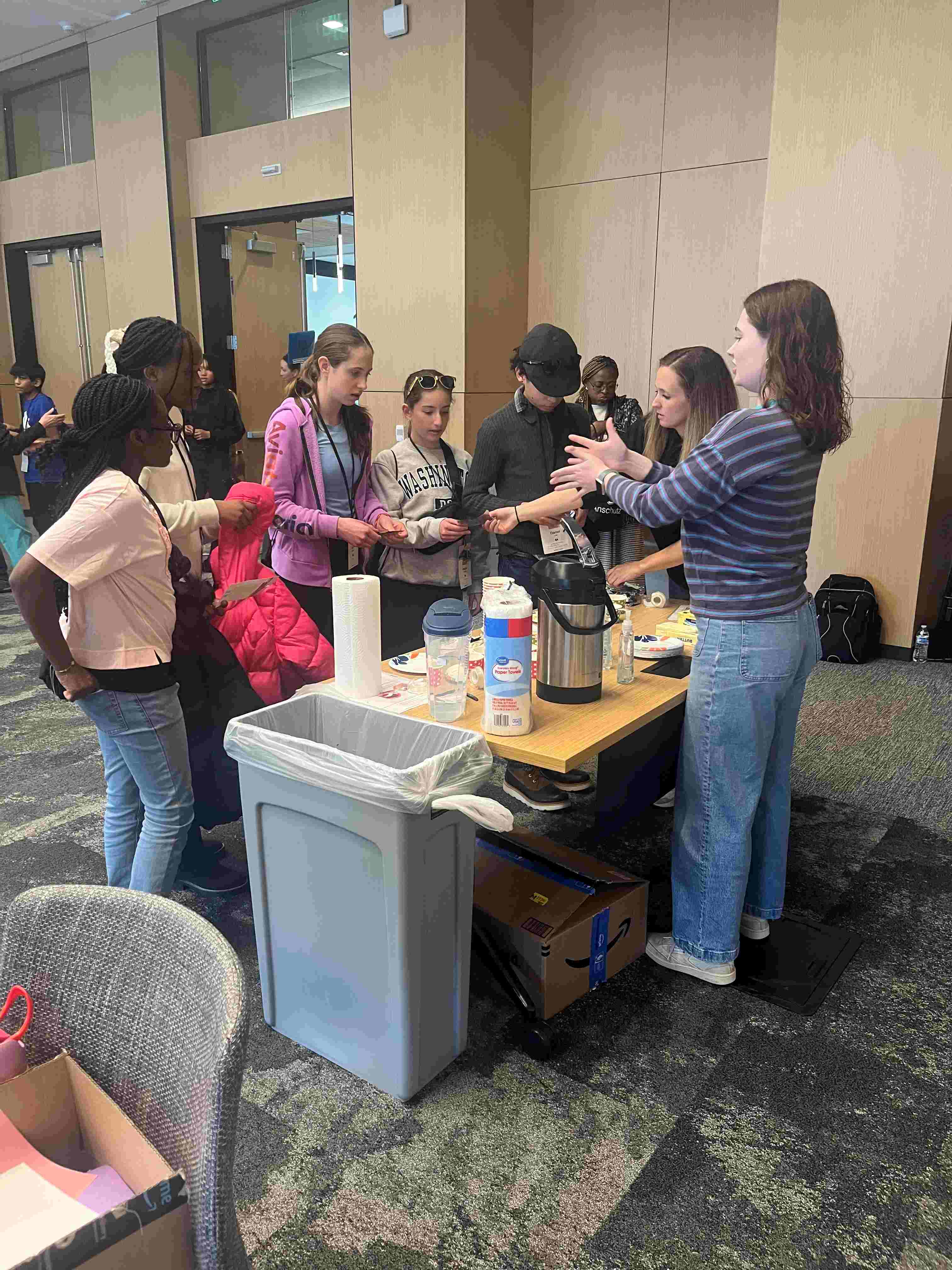 Photooftablewithyouthscienceactivitywithvolunteersandstudents