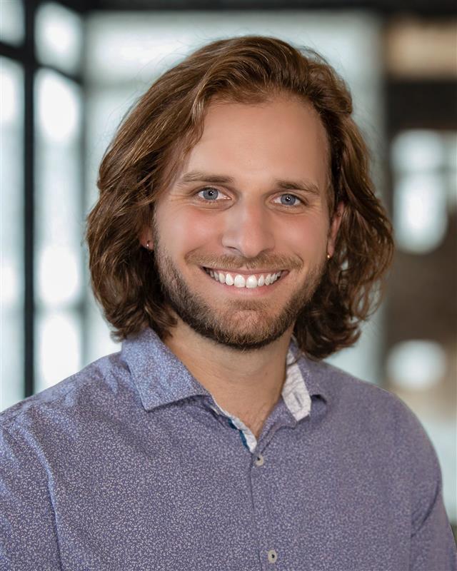 man smiling with a blue button down shirt