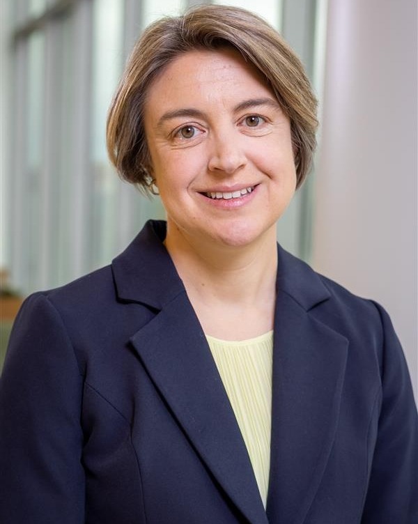 white female doctor with short brown hair, blue suit