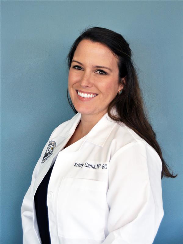 female nurse practitioner smiling wearing her white coat