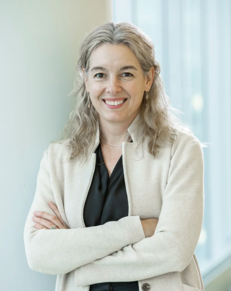 woman standing smiling with arms crossed