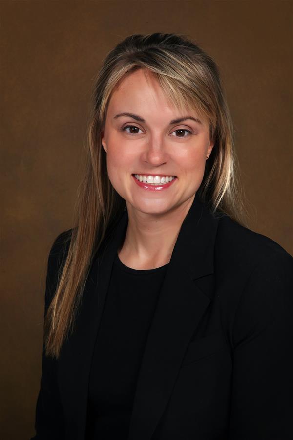 female with a black blazer and white shirt, blonde hair, smiling for a headshot