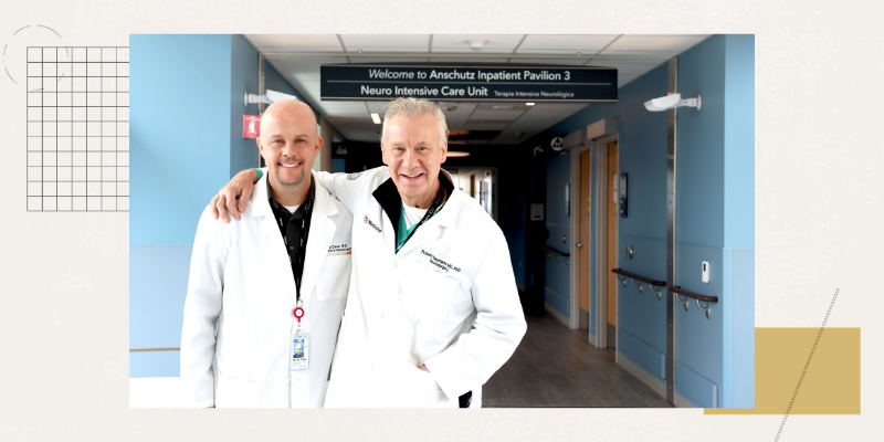 David Case, MD, and Robert Neumann, MD, PhD, in the hall of the hospital in front of the neuro intensive care unit sign