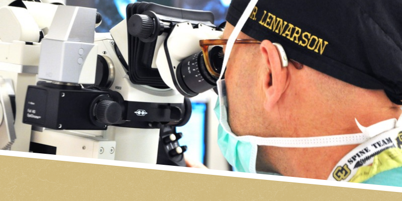 Peter Lennarson, MD, looking through a surgical microscope
