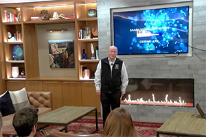 Speaker standing in front of a fireplace and a screen