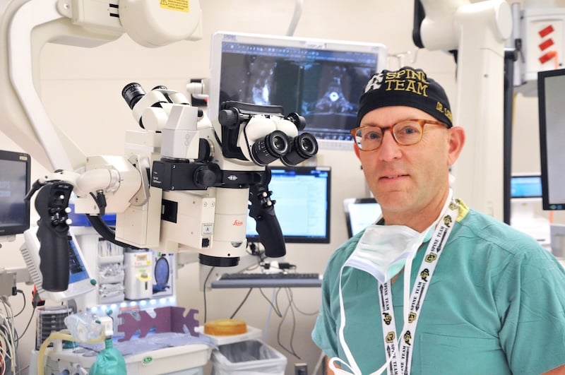Peter Lennarson, MD, with the surgical microscope in the operating room