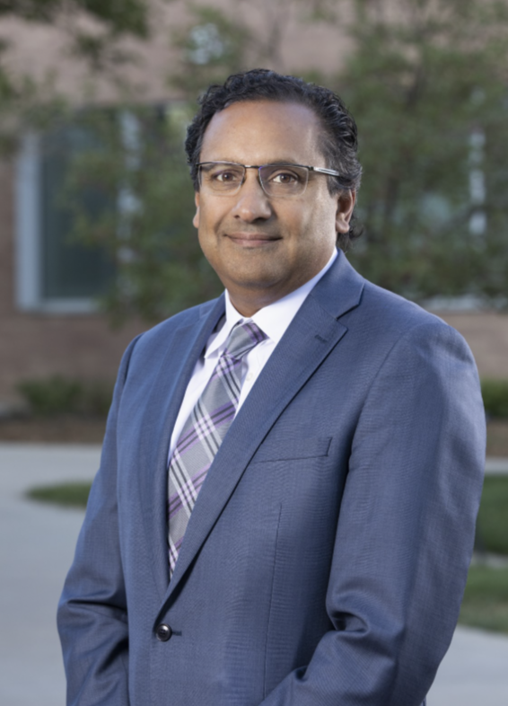 headshot of a doctor outside with a blue suit on