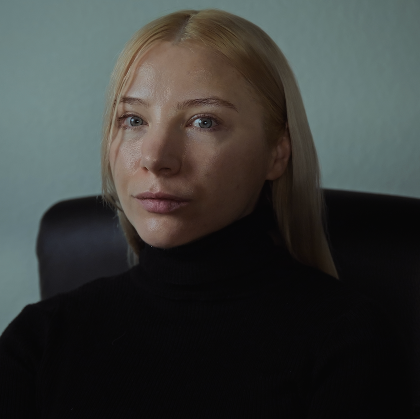 female woman headshot, blonde hair and black turtle neck