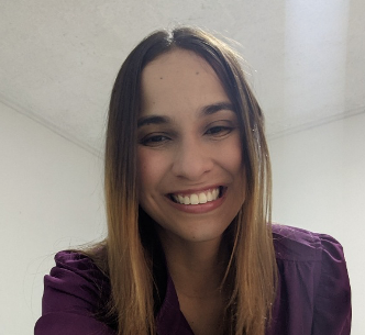 female with a purple shirt on and brown/blonde hair smiling