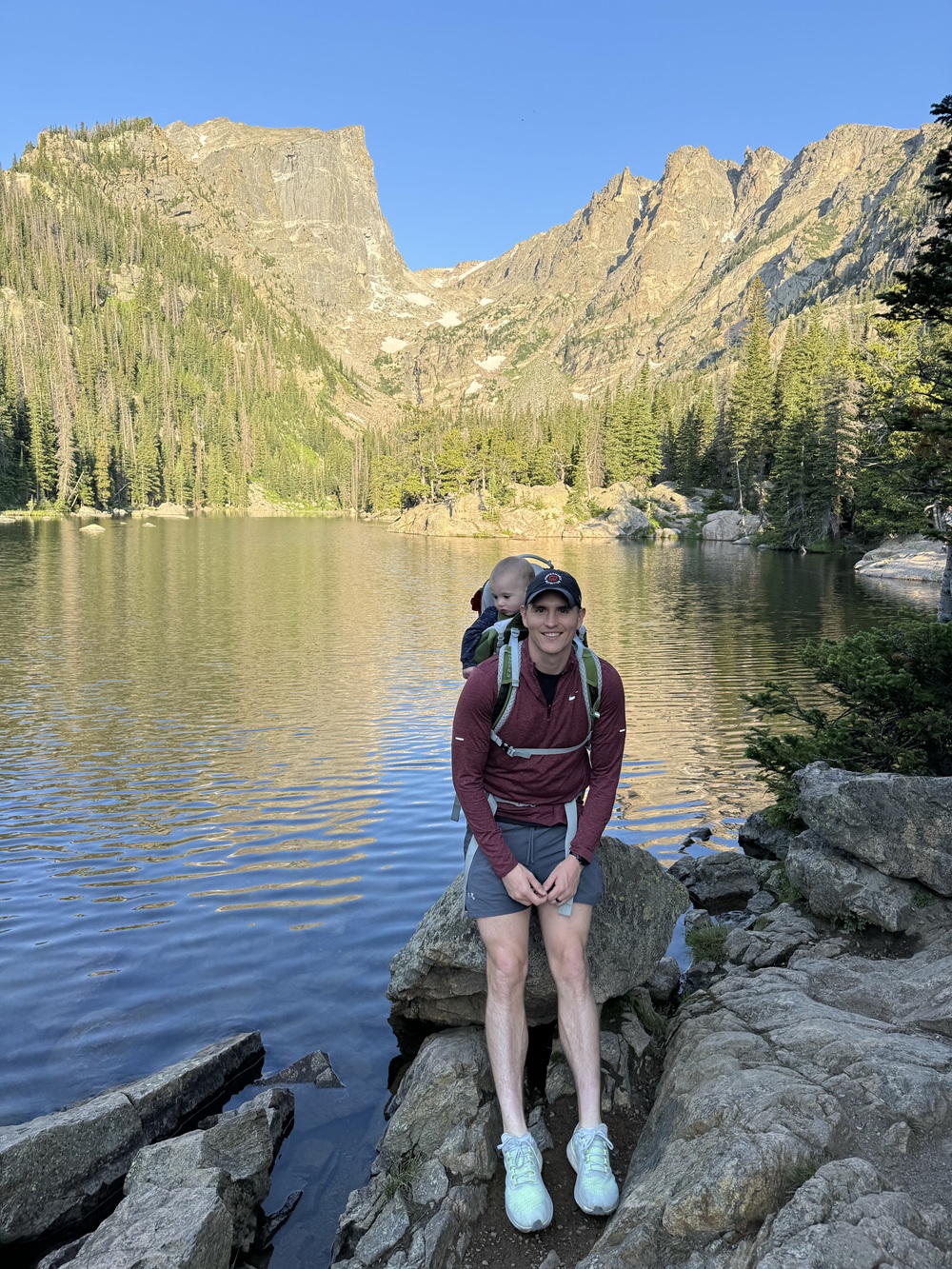 Dr. Cassinat with a baby by an alpine lake.