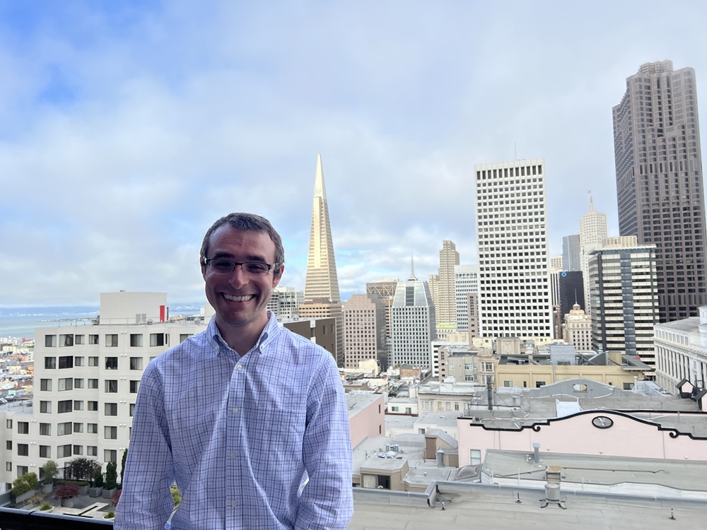 Dr. Darevsky next to an urban skyline.