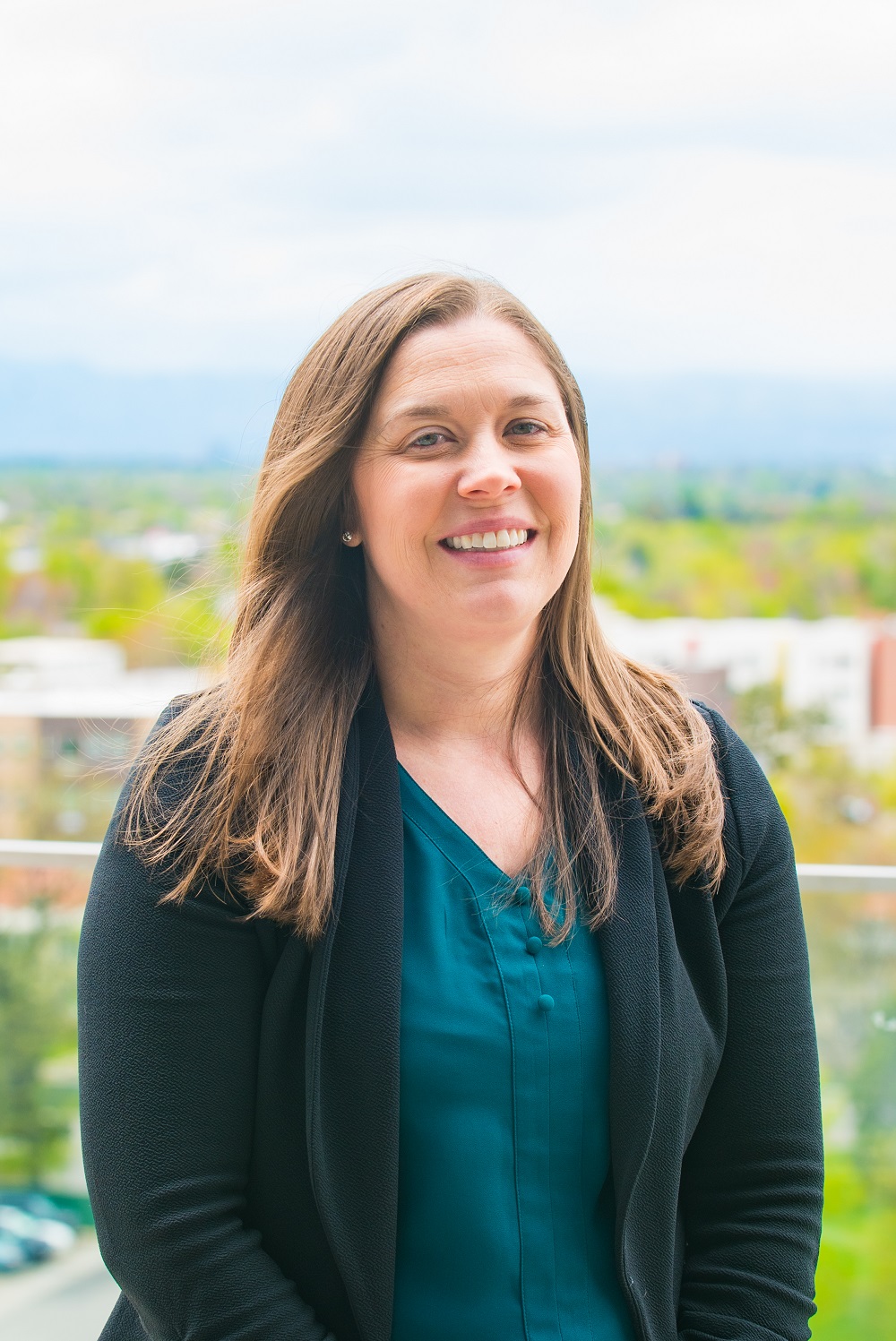 Headshot of Dr. Logan with an outdoors urban background.