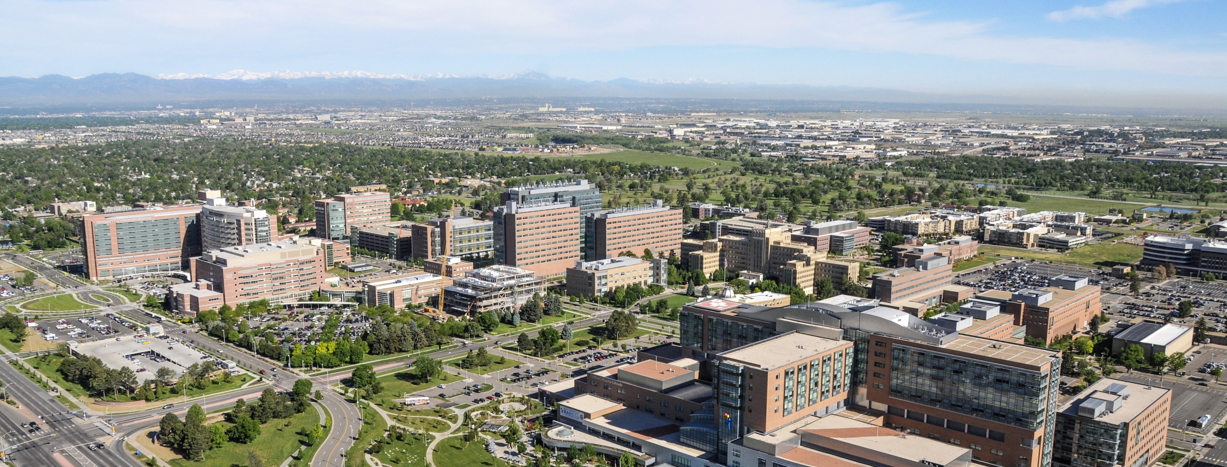 CU Anschutz campus aerial photo with blue sky and mountains in the background