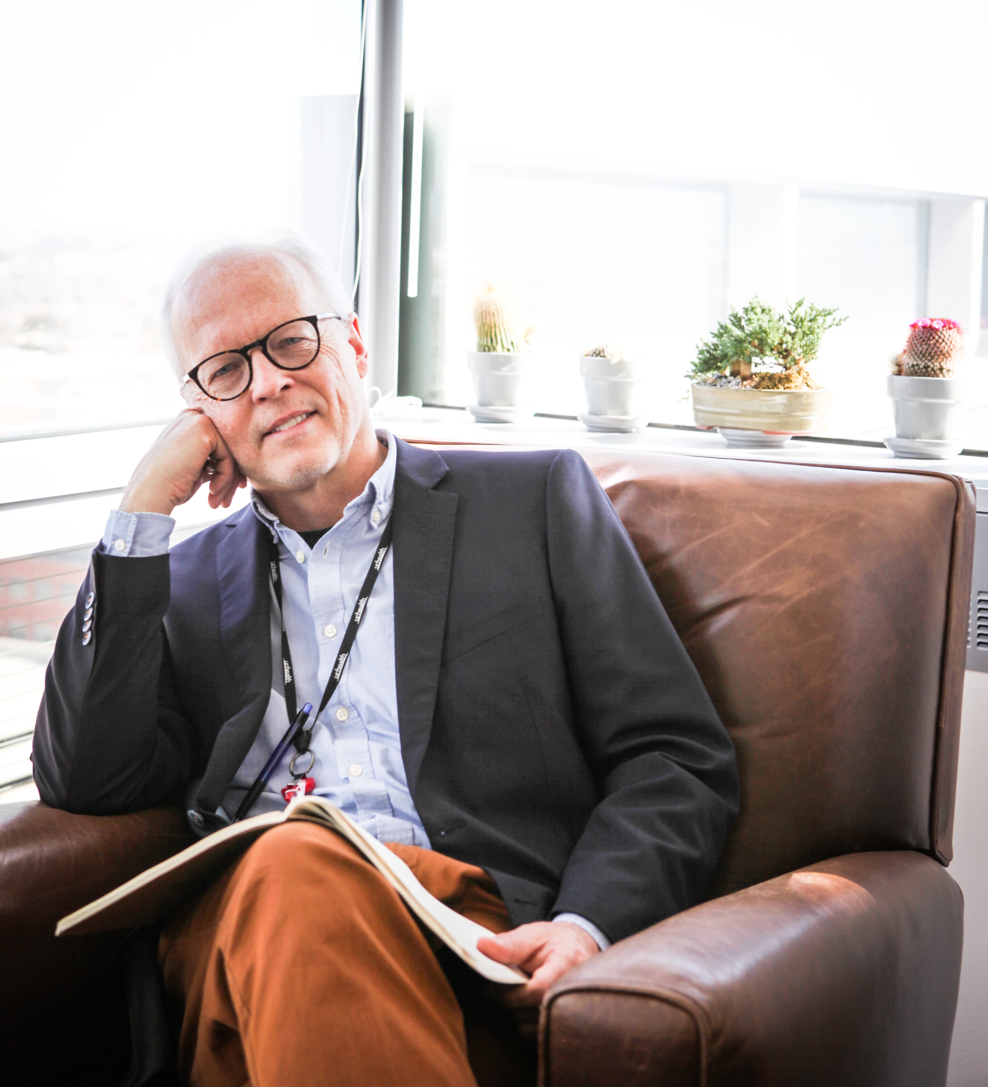 Mansittingathisofficeonaarmchair