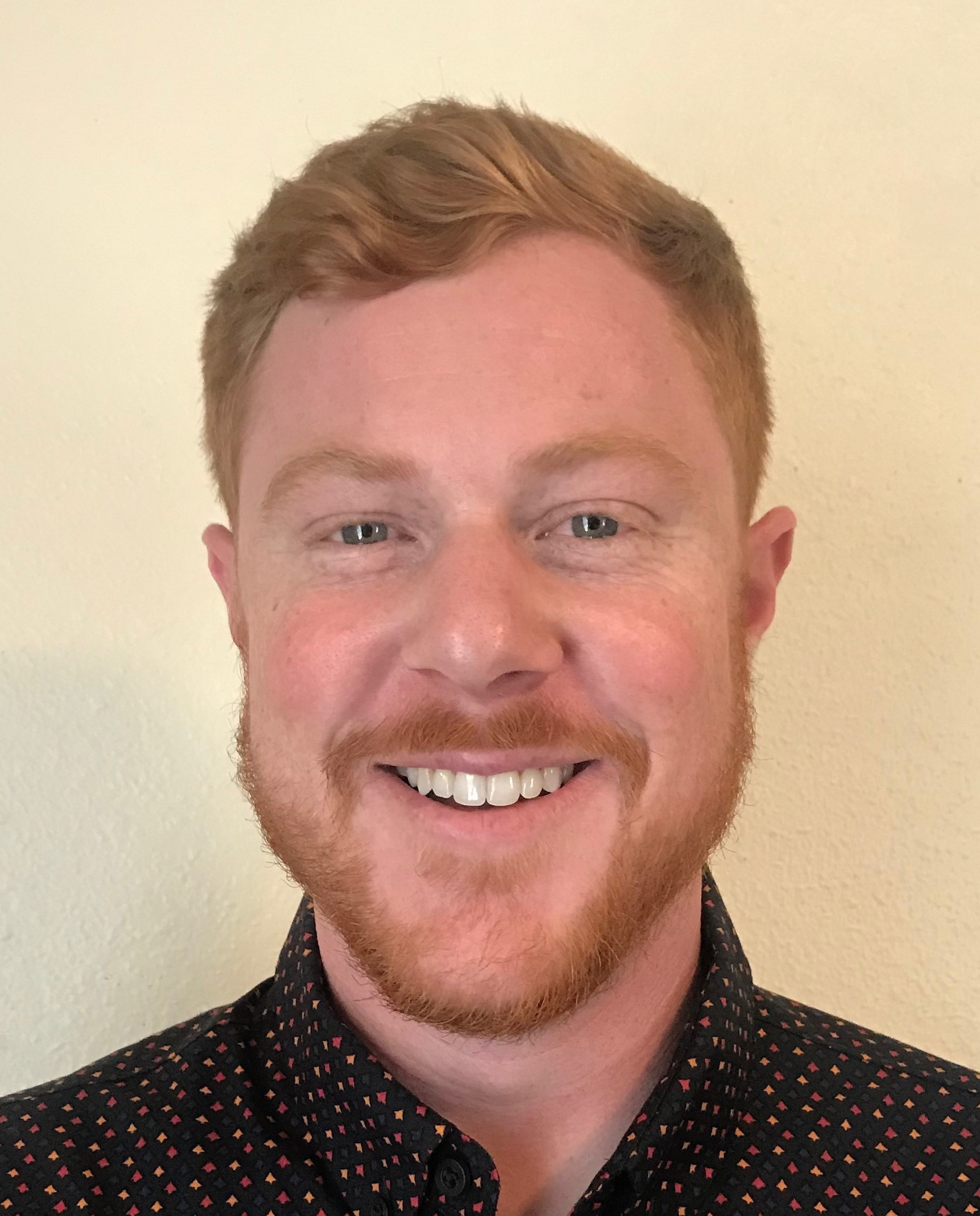 Professional headshot of man in collared shirt.