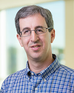 Headshot of a man in a colored shirt