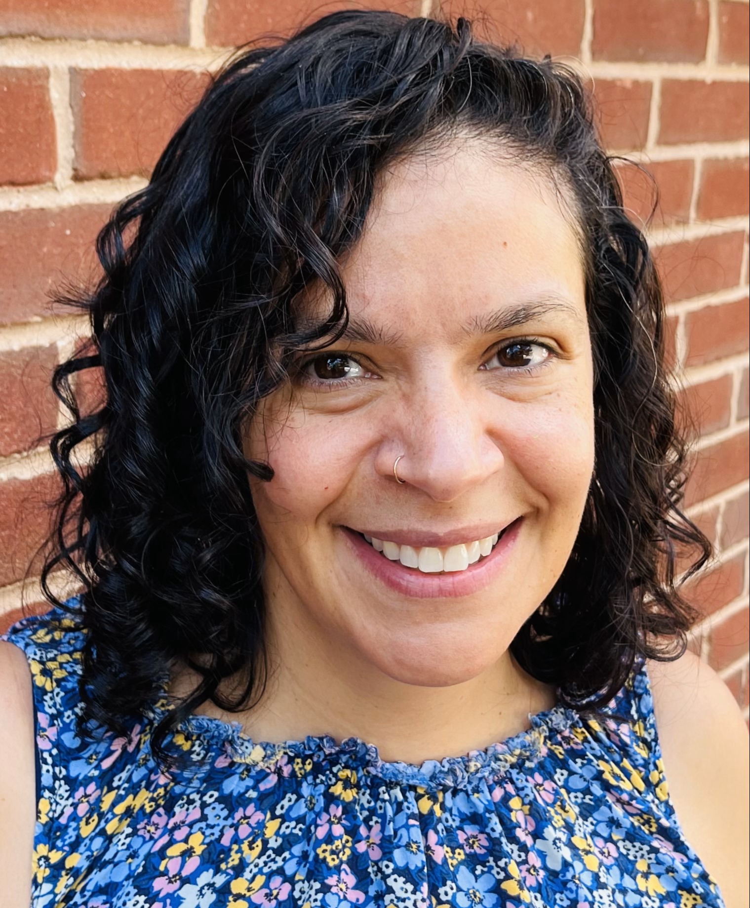 Headshot of woman with brick background