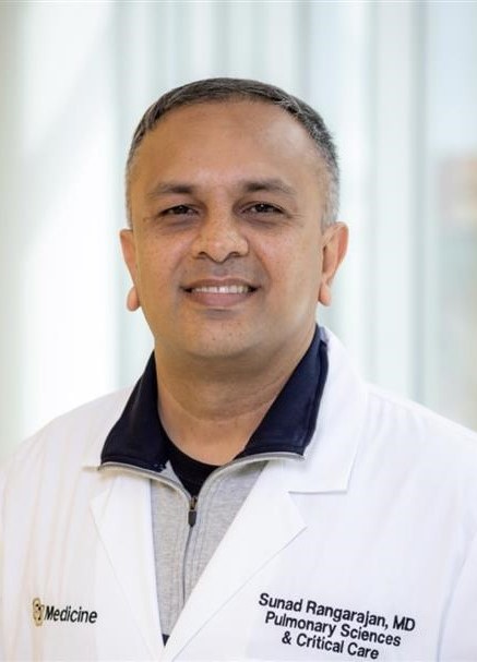 Professional headshot of man in lab coat